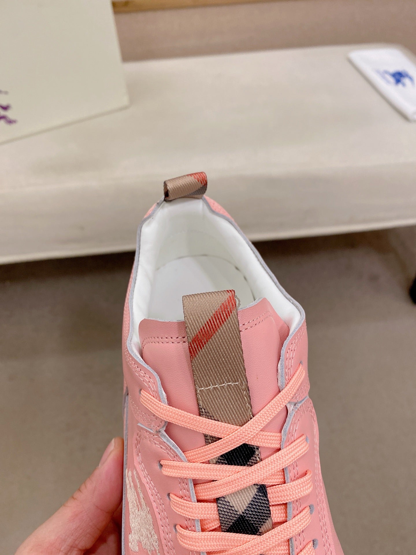 Pink sneaker tongue and lace detail with geometric mesh lining