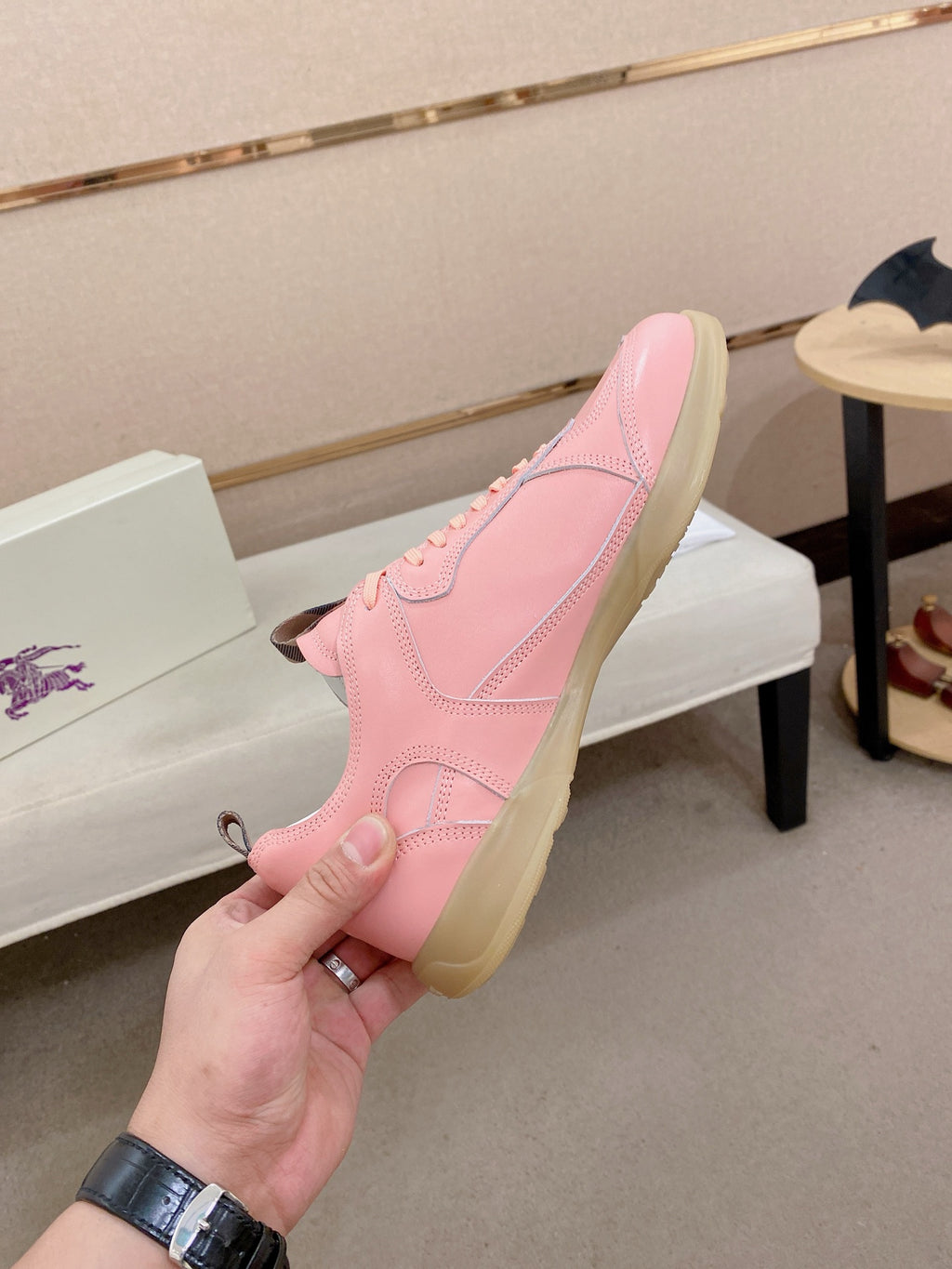 Pink low-top sneaker heel view with stitched panels and gum sole