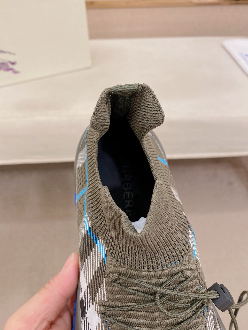 Gray knit sneaker collar and laces with plaid stripe detail
