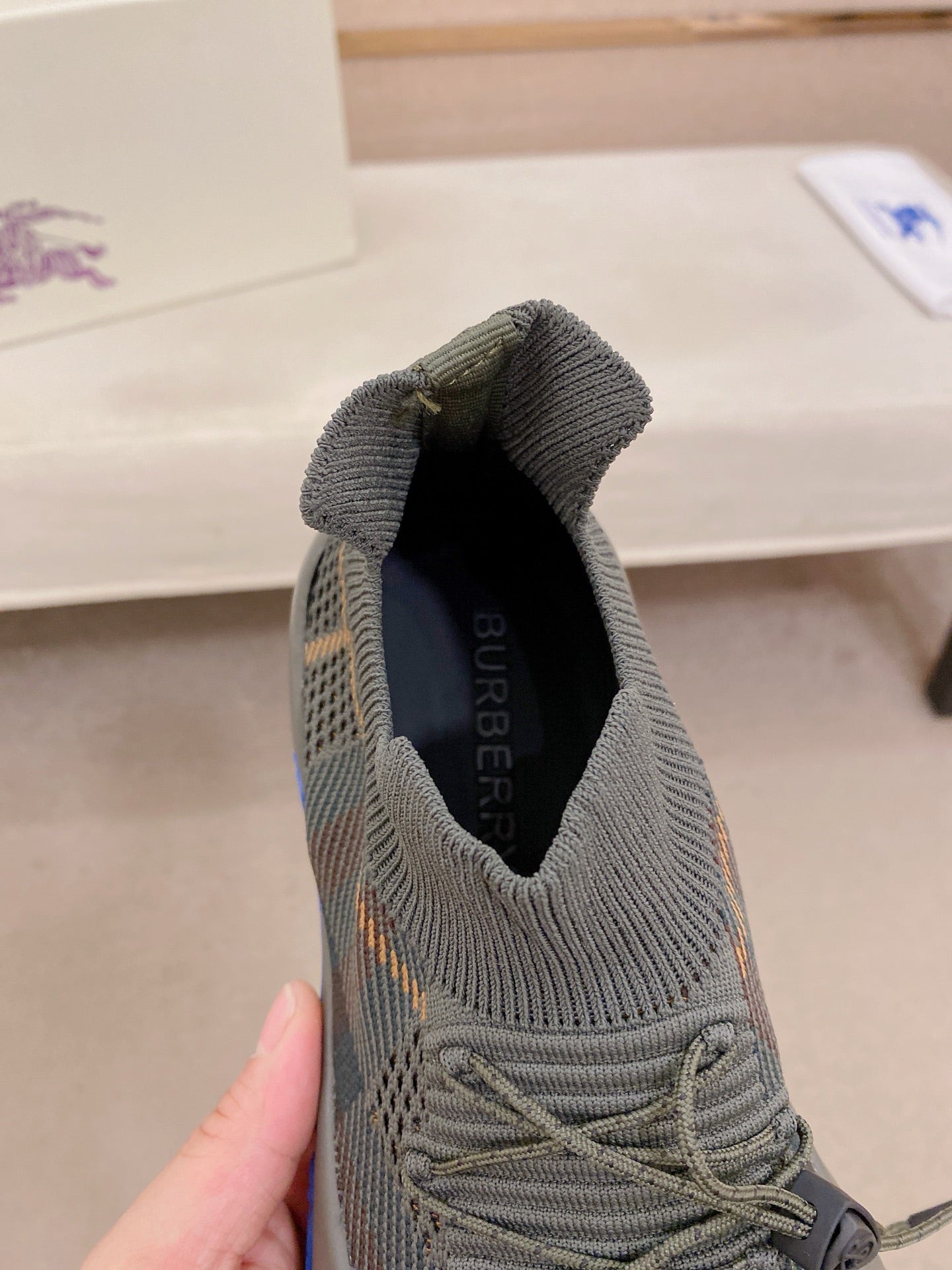 Gray knit sneaker lining showing Burberry logo near ankle