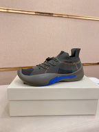 Gray knit sock sneakers with black laces and blue sculpted sole