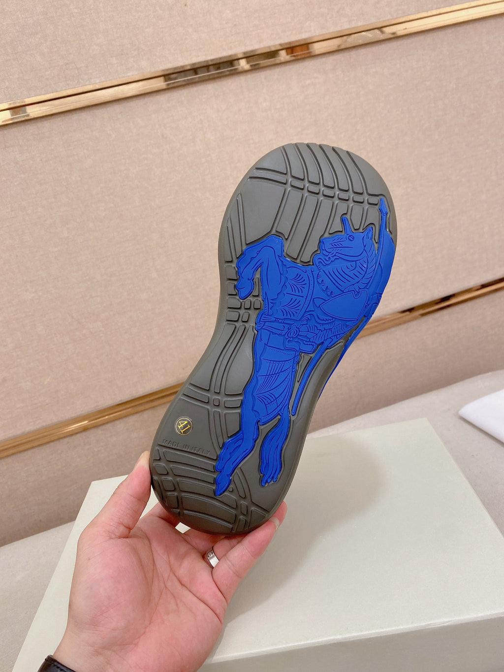 Gray rubber outsole with deep grooves and blue tread insert