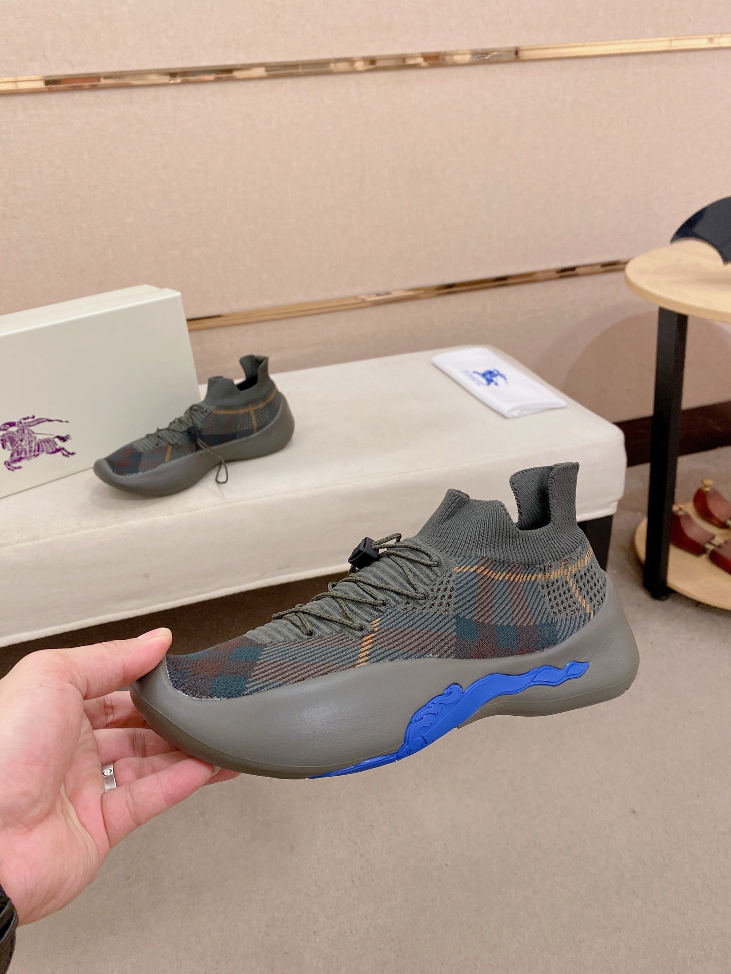 Gray knit sneakers with multicolor pattern upper and blue side sole trim
