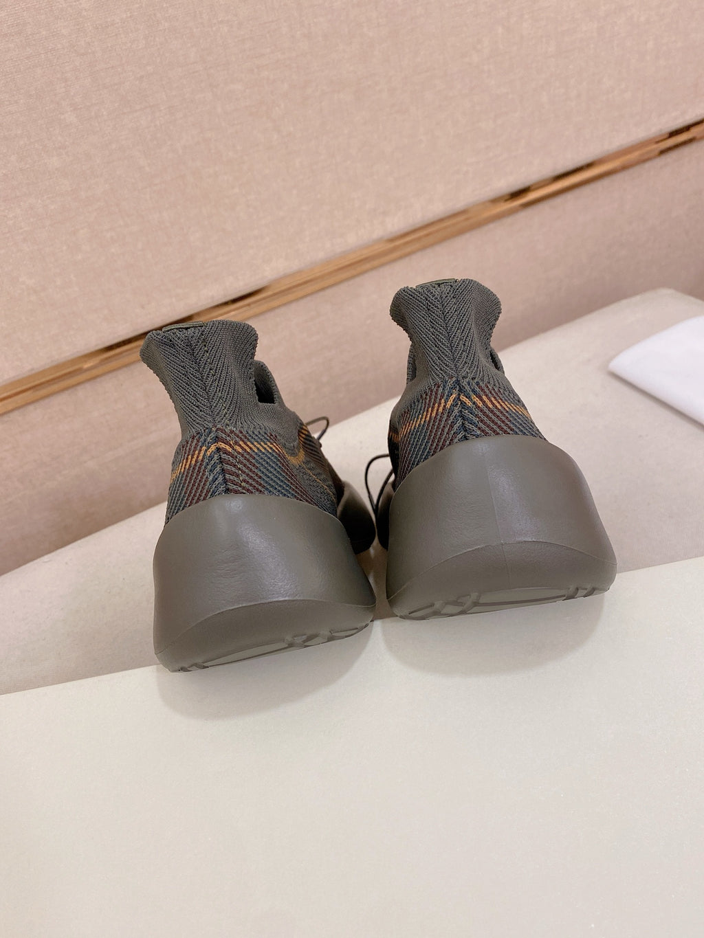 Back view of gray knit sneakers with blue sole and lace-up front
