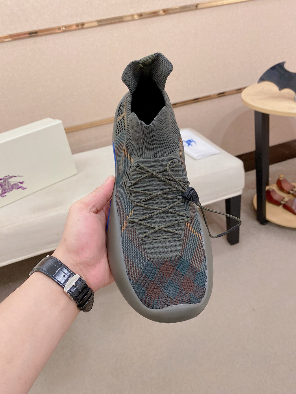 Gray knit slip-on sneakers with elastic collar, laces, and blue sole