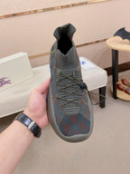 Gray knit slip-on sneakers with elastic collar, laces, and blue sole