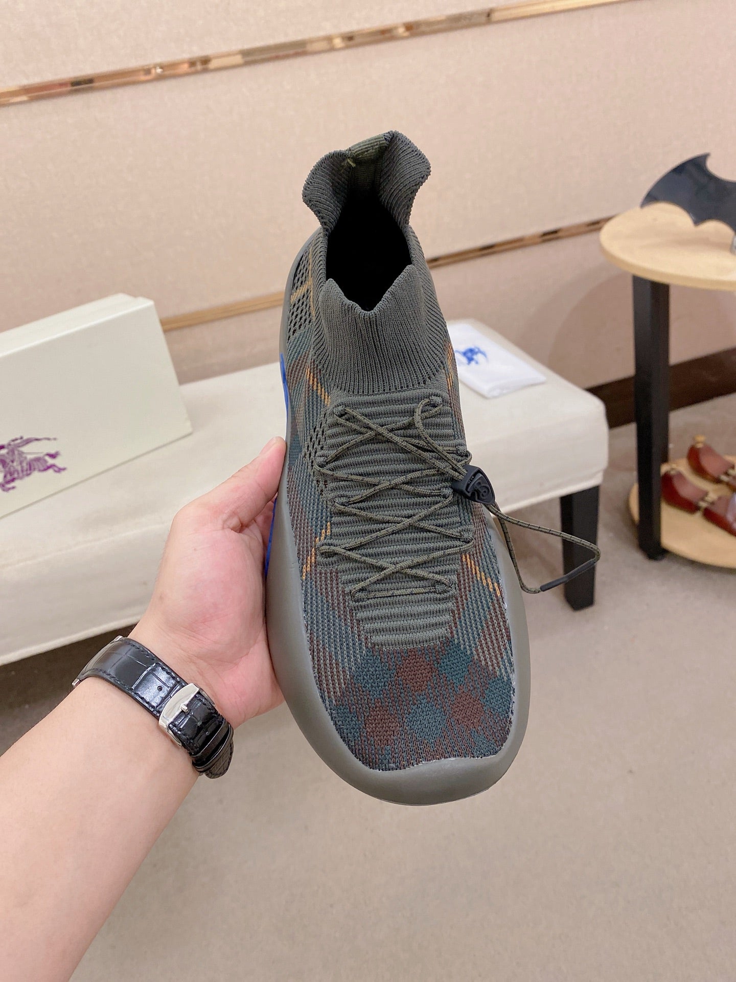 Gray knit slip-on sneakers with elastic collar, laces, and blue sole