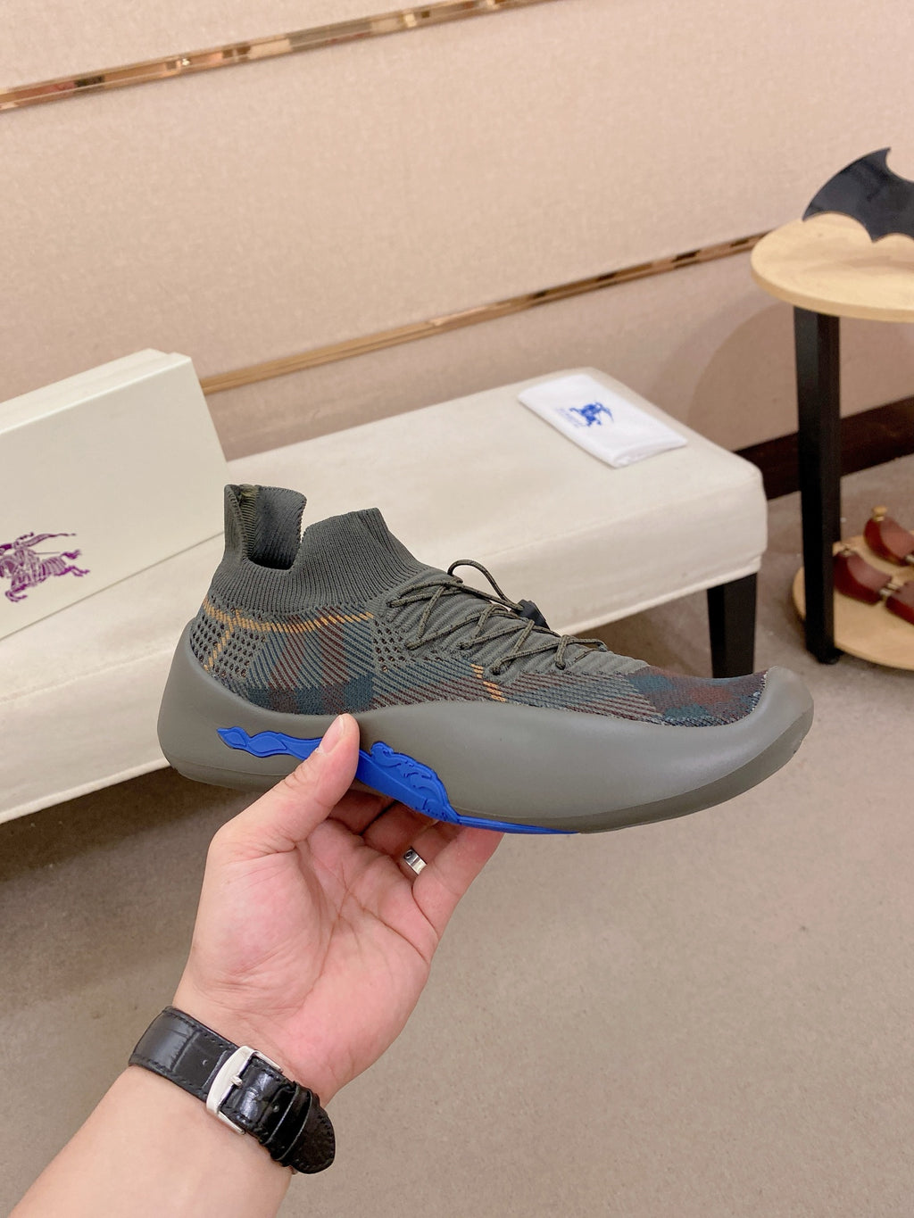 Gray knit sneaker with lace-up front and blue accent sole