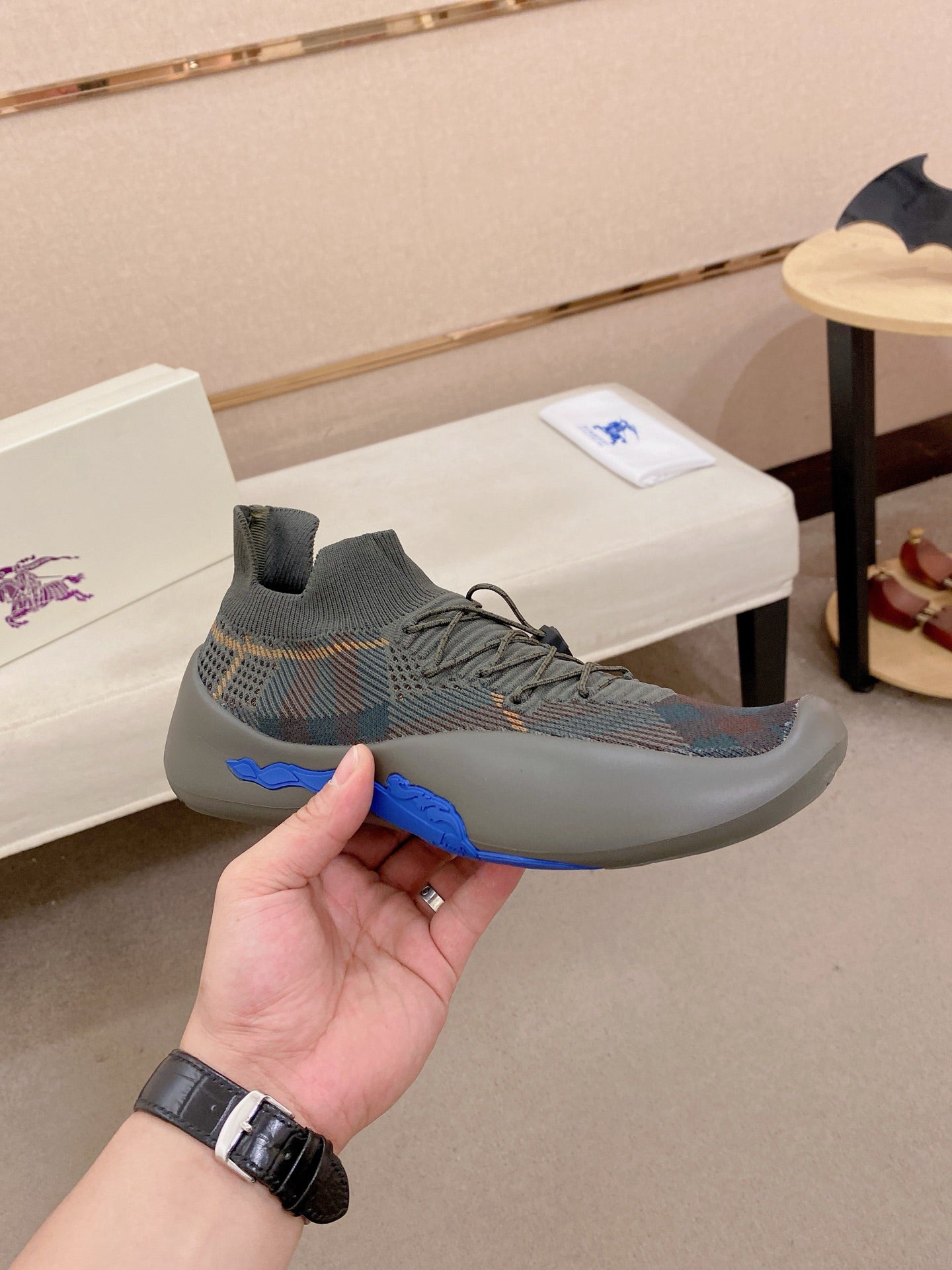 Gray knit sneaker with lace-up front and blue accent sole