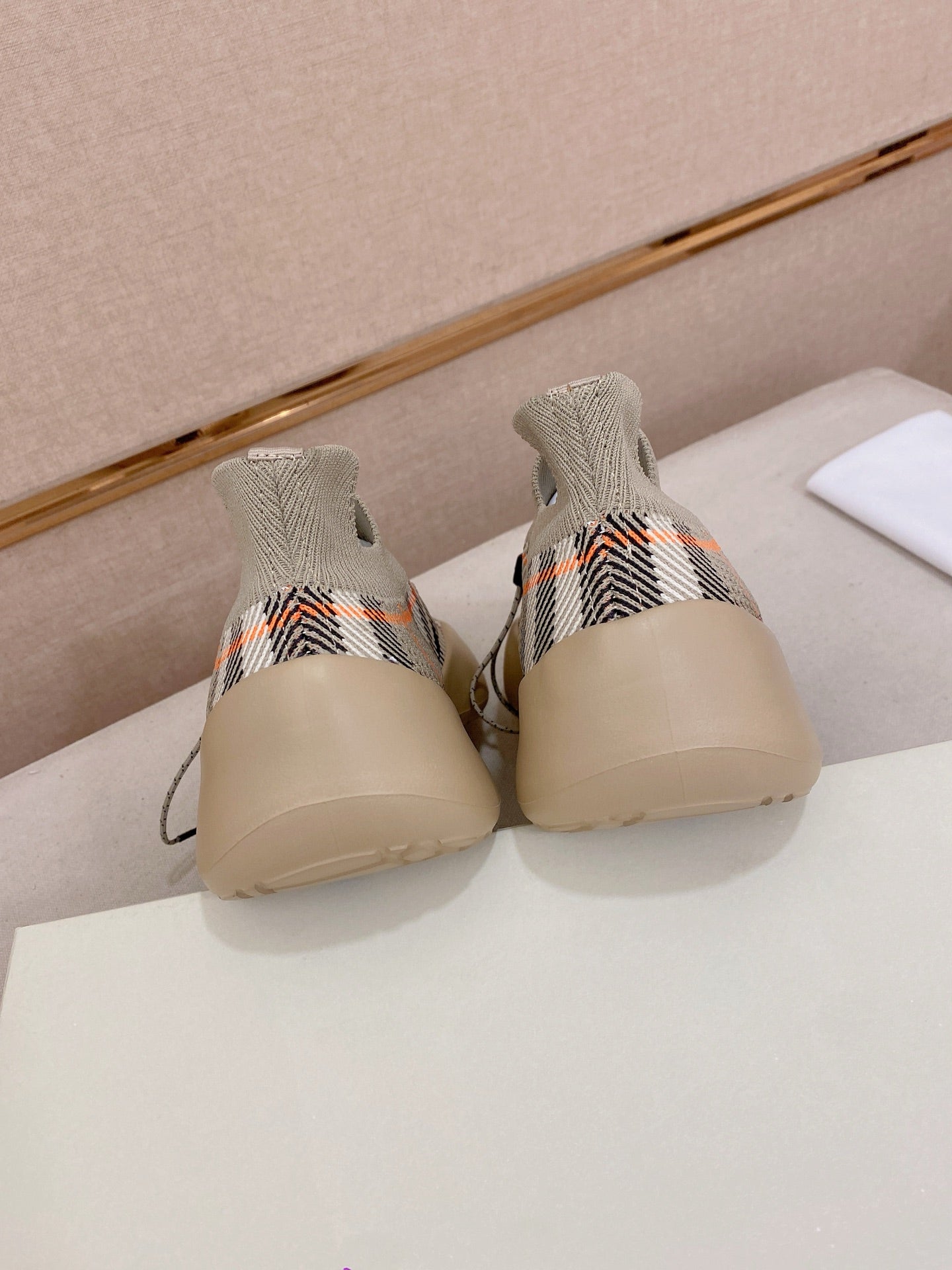 Back view of beige check knit sneakers with blue sole trim