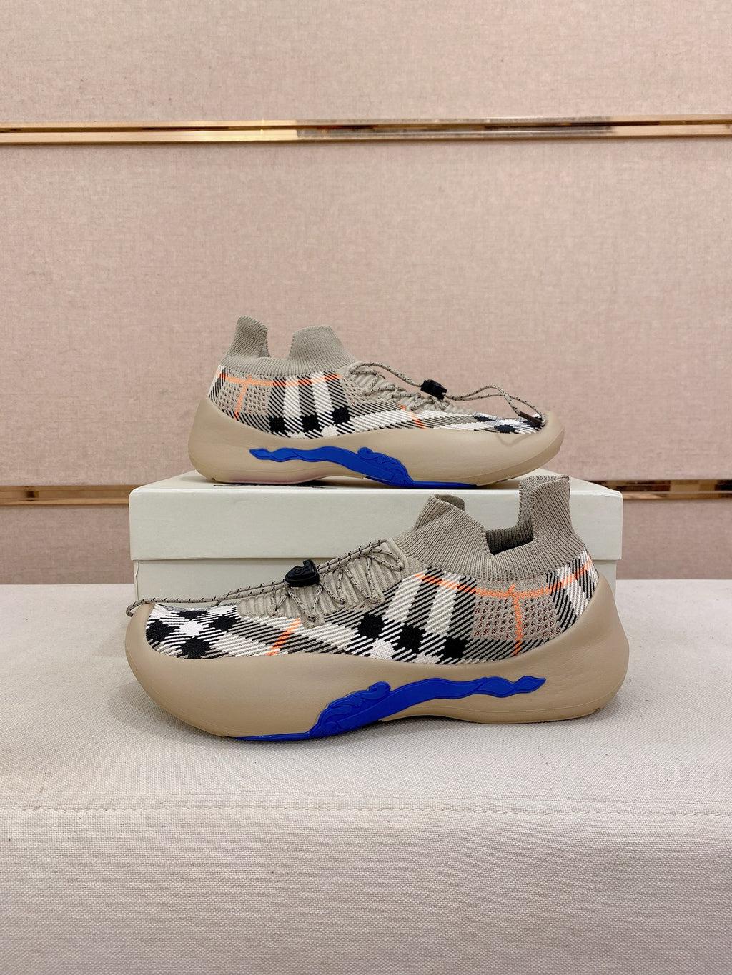 Pair of beige check knit sneakers with blue sole and lace-up front