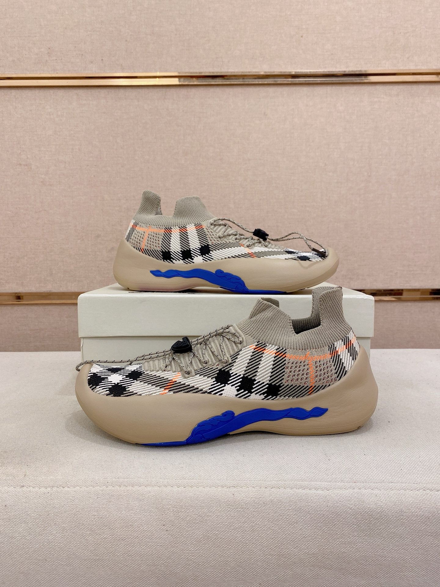 Pair of beige check knit sneakers with blue sole and lace-up front