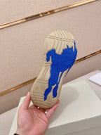 Rubber outsole of knit sneaker with blue traction pattern on beige sole