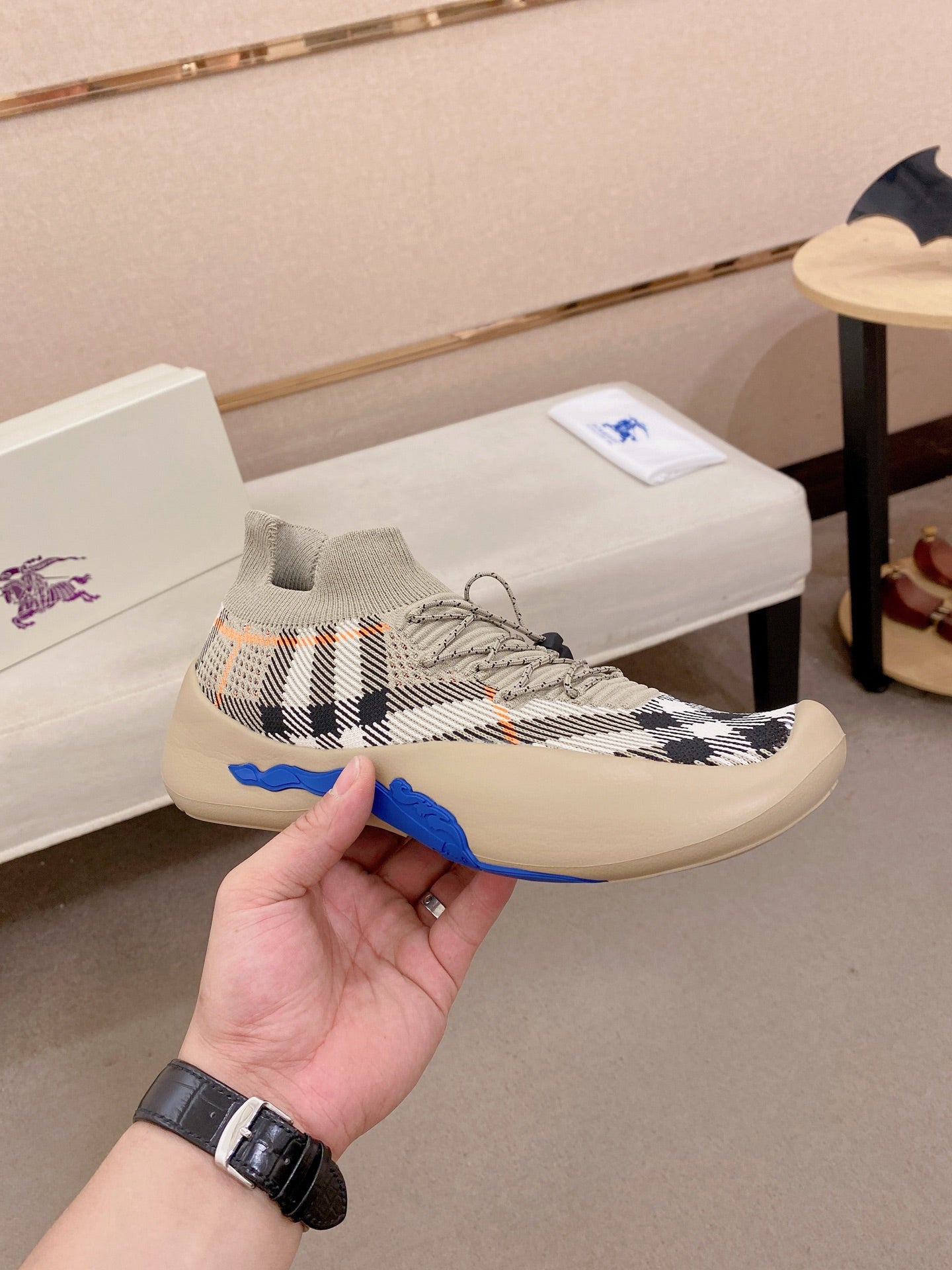 Lace-up knit sneaker with beige, black, and orange check pattern, blue sole edge