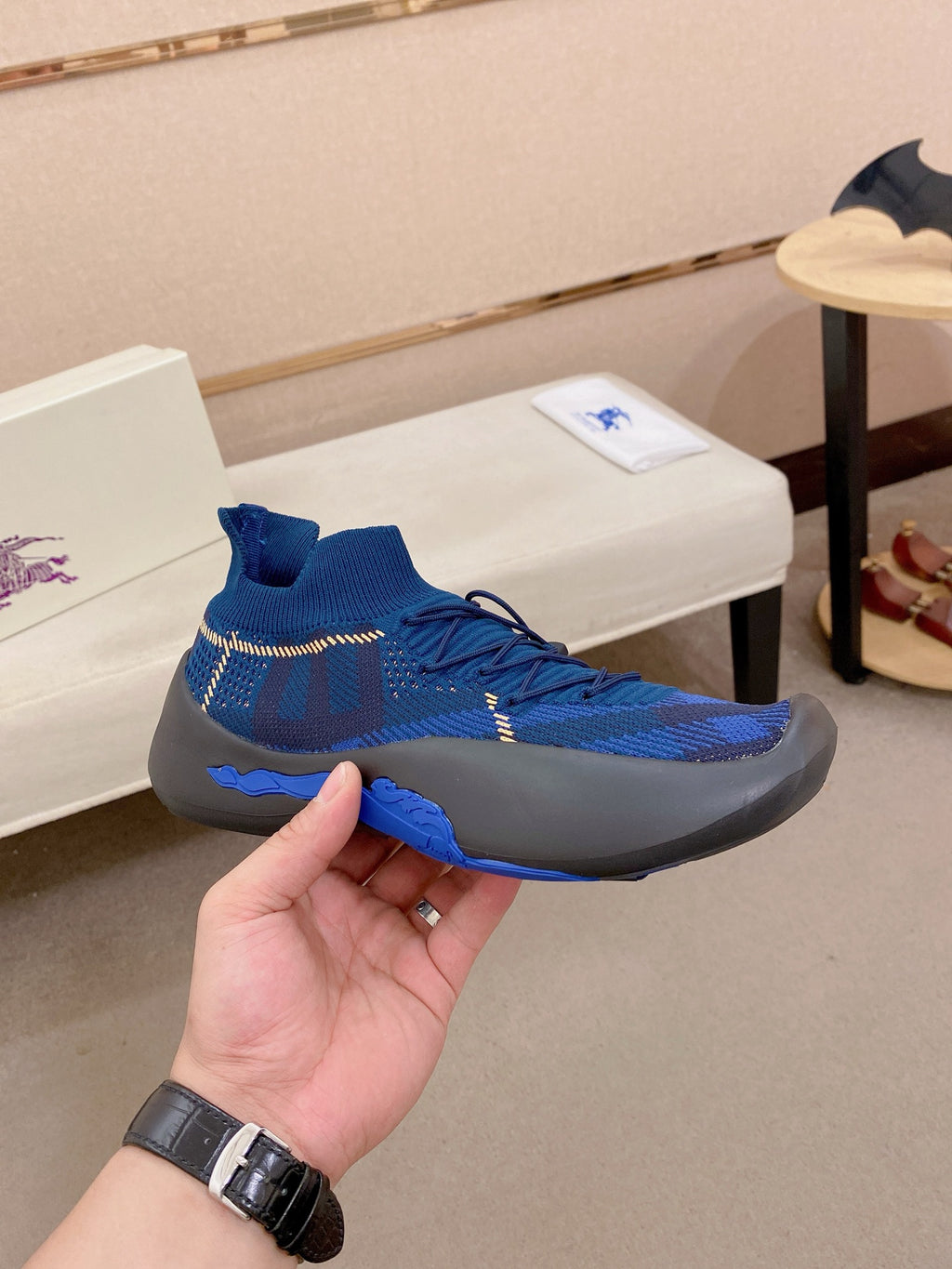 Blue knit sneaker held up, textured knit and blue sock collar detail