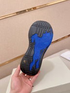 Blue and black rubber outsole with tread pattern, held in hand