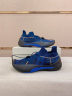 Pair of blue knit sneakers on white display cushion, lace detail