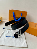 Black Louis Vuitton belt with gold-toned LV buckle and embossed monogram strap.
