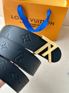 Black Louis Vuitton belt with gold-toned LV buckle detail and embossed flower motif.