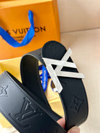Black Louis Vuitton belt buckle close-up with LV motif on embossed leather strap.