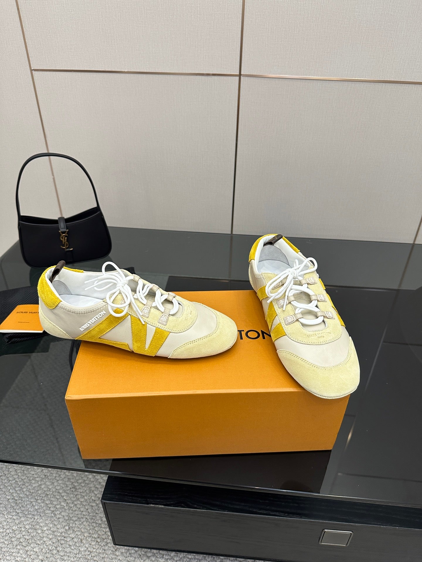 Louis Vuitton sneakers pair, cream with yellow accents and white laces, front angled view