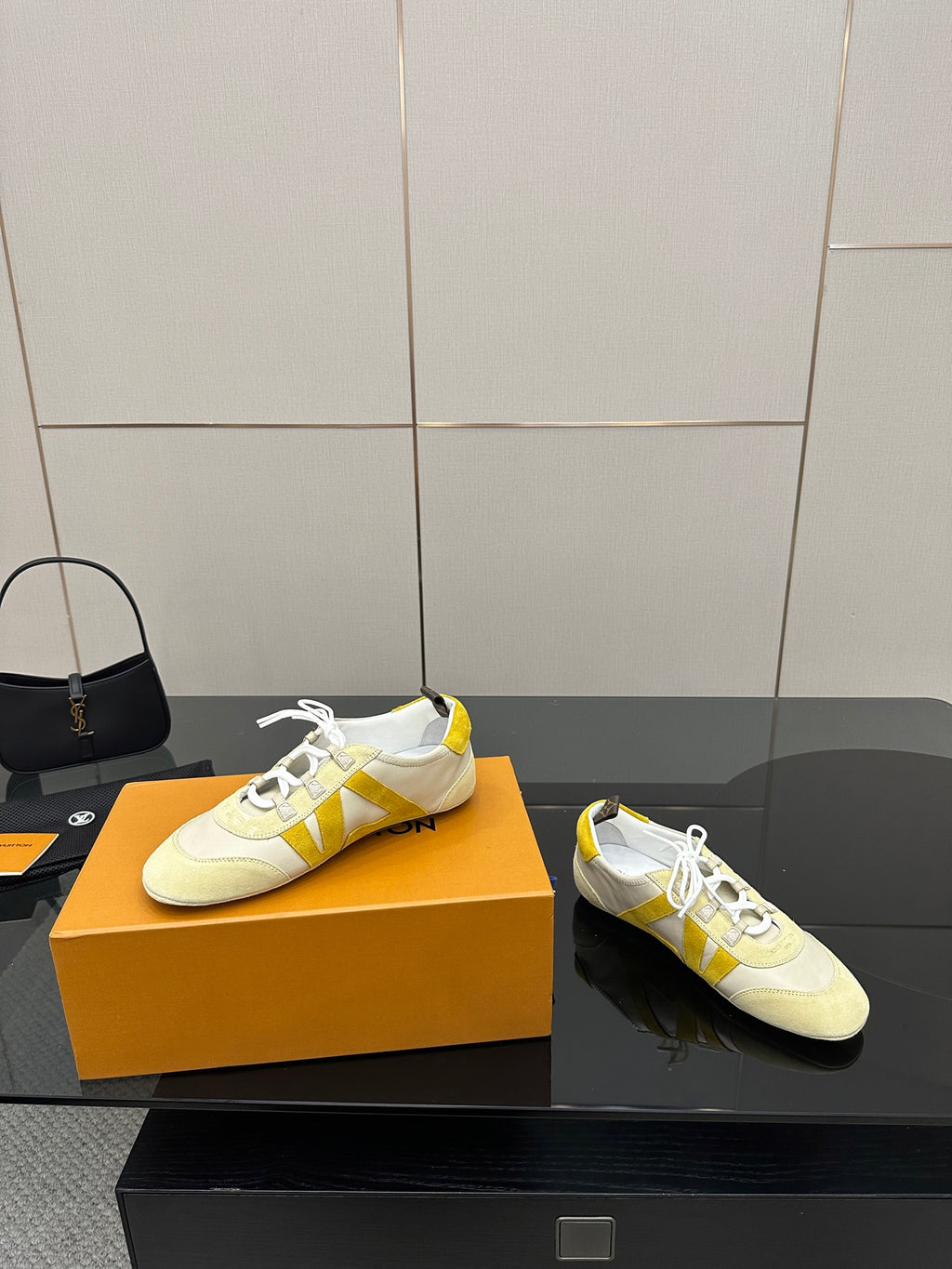 Louis Vuitton sneakers pair, cream uppers with yellow accents and white lace-up style