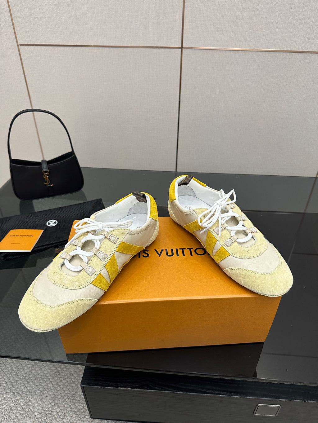 Louis Vuitton sneakers with yellow stripe detail and white laces, angled side view