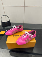 Pink low-top sneakers with white laces and Louis Vuitton text on the side