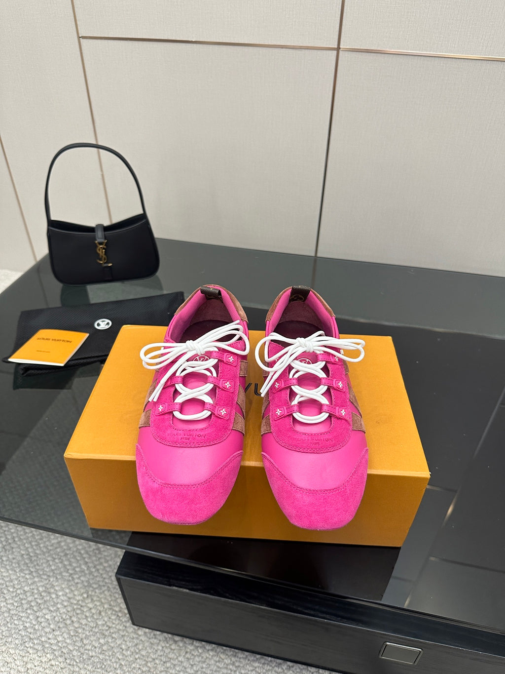 Pink low-top sneakers with white lace-up cords and decorative logo stripes