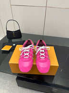 Pink low-top sneakers with white lace-up cords and decorative logo stripes