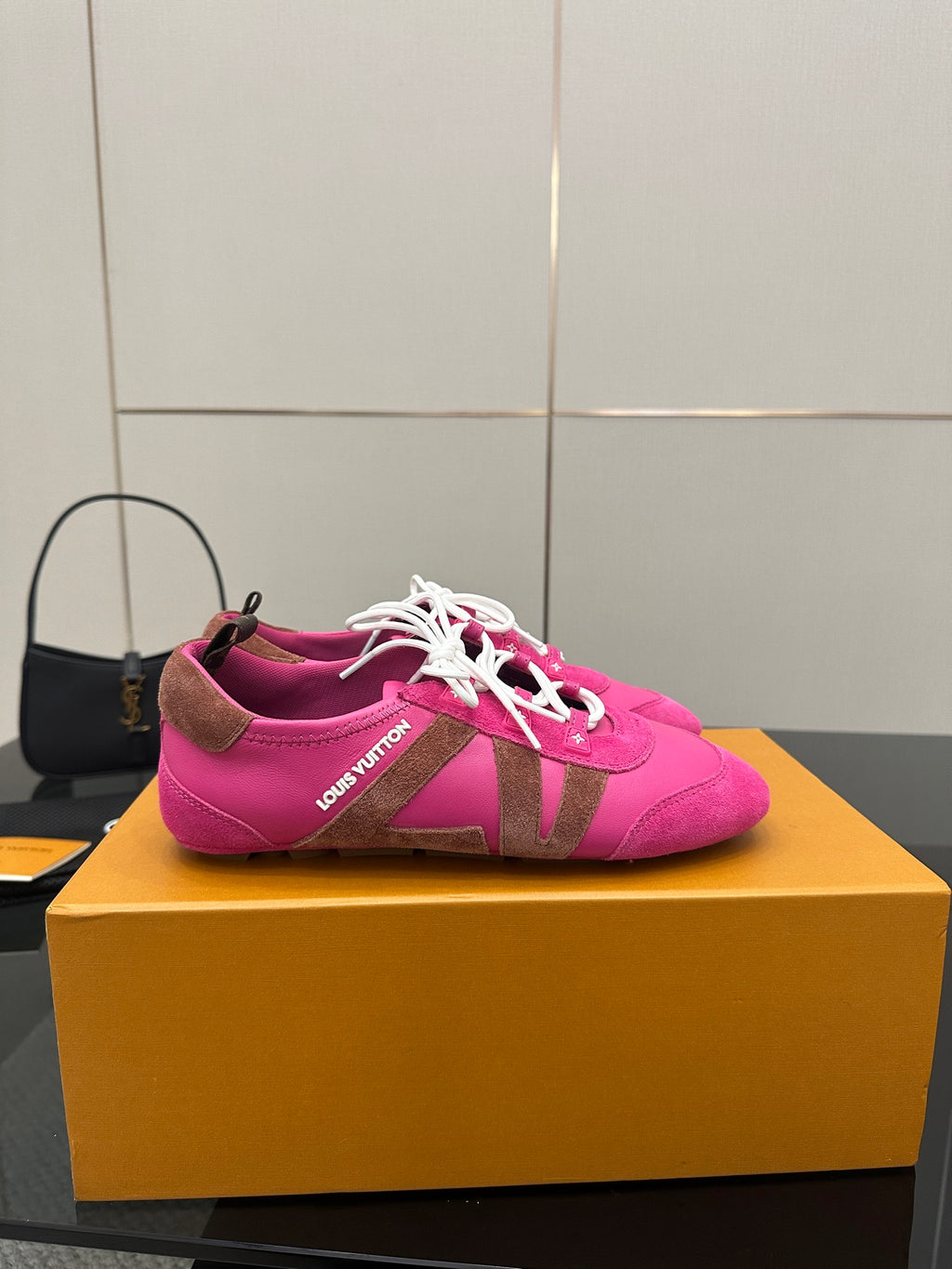 Pink lace-up sneakers with white laces and Louis Vuitton branding on side