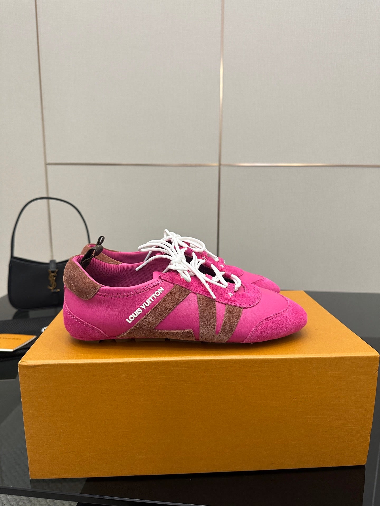 Pink lace-up sneakers with white laces and Louis Vuitton branding on side