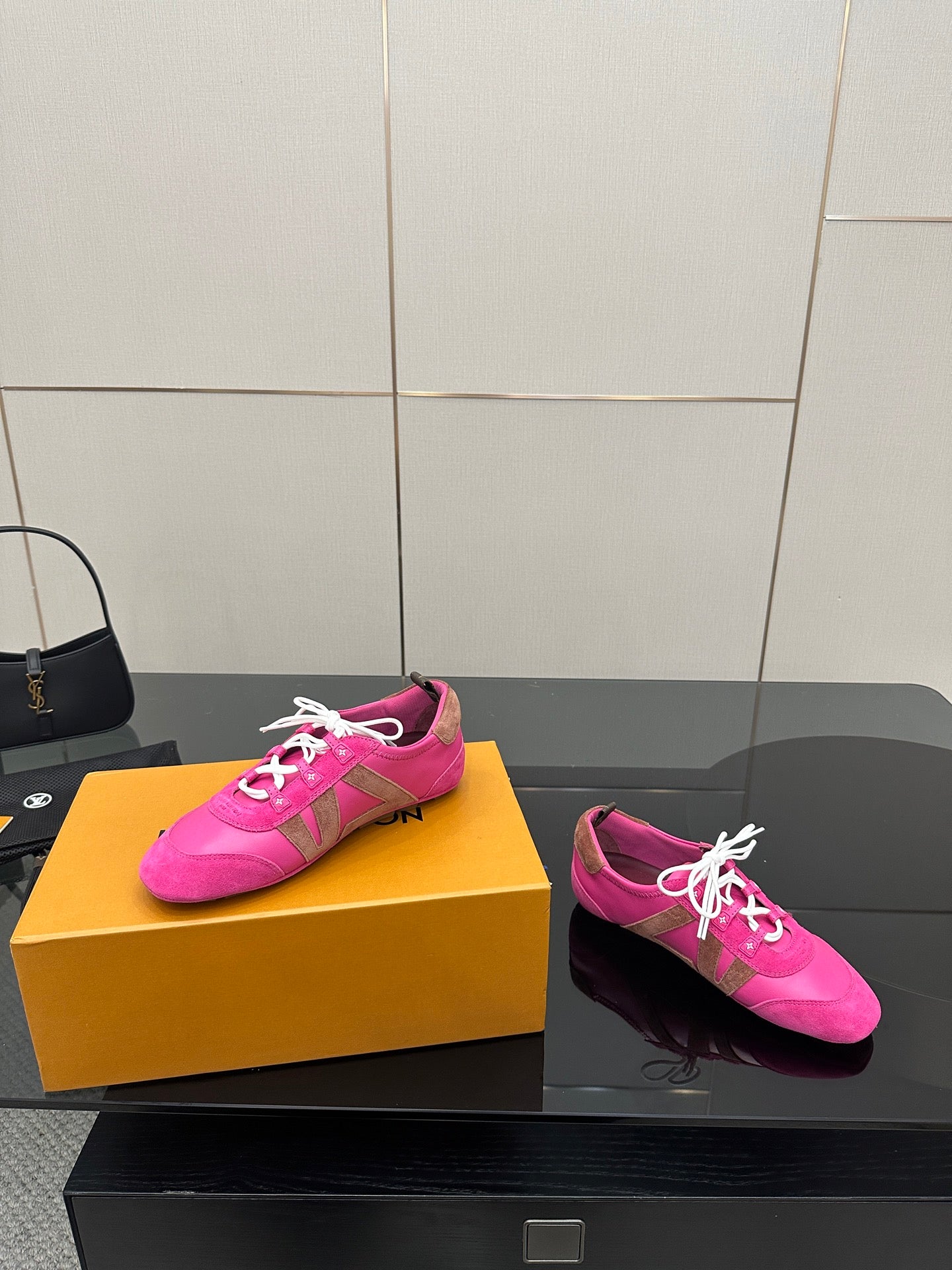 Pink low-top sneakers with white lace-up cords and side logo accents
