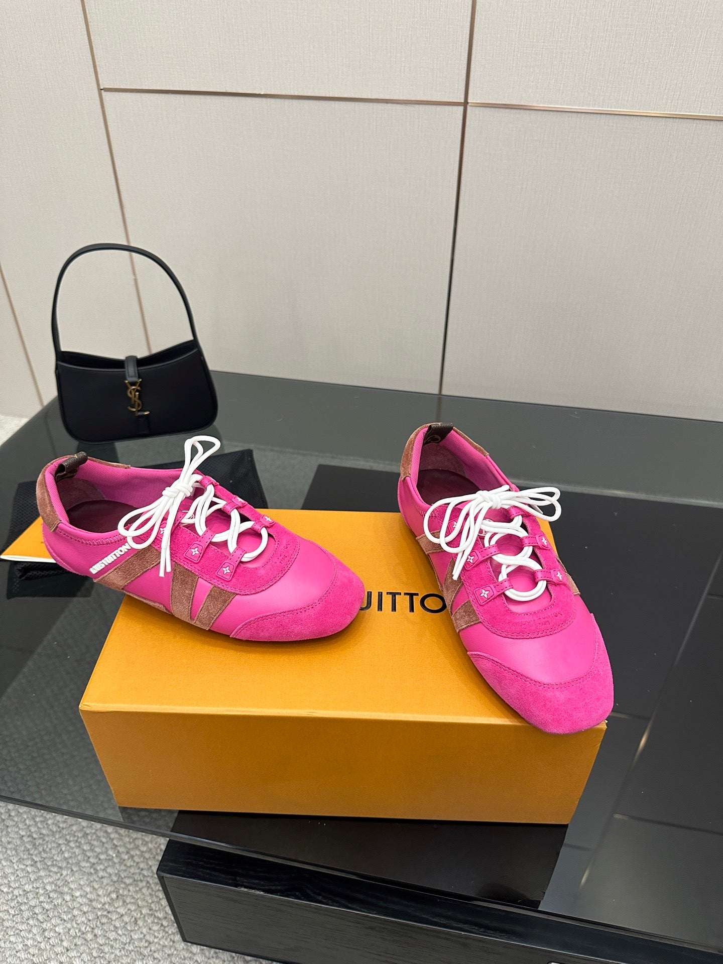 Pair of pink lace-up sneakers with white cords and decorative side trim