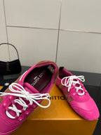 Close-up of pink lace-up sneaker showing padded collar and white laces