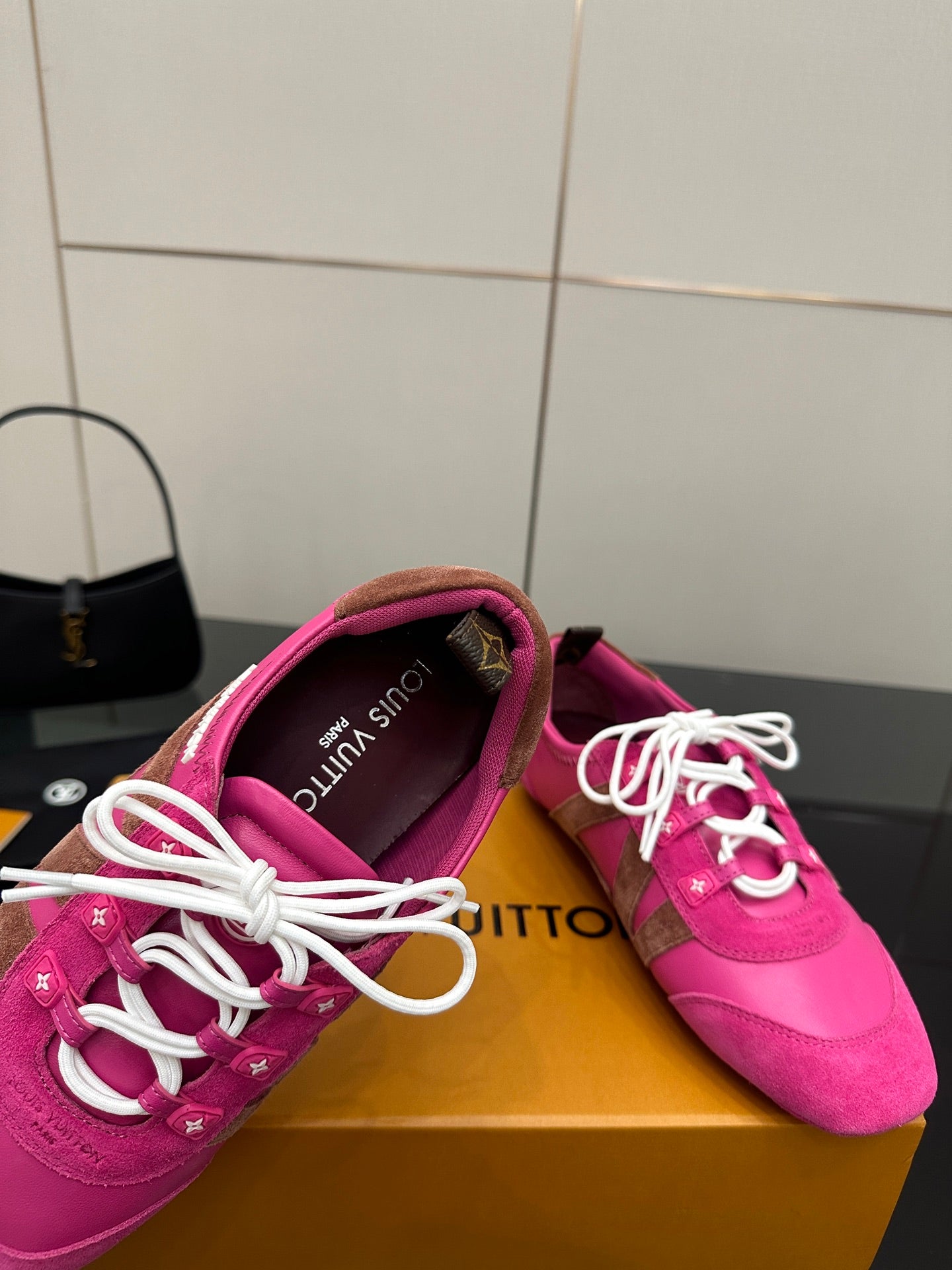 Close-up of pink lace-up sneaker showing padded collar and white laces