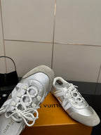 Louis Vuitton white leather sneakers close-up, lace-up front and side logo