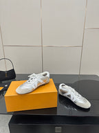 Louis Vuitton white leather sneakers, side view of lace-up uppers