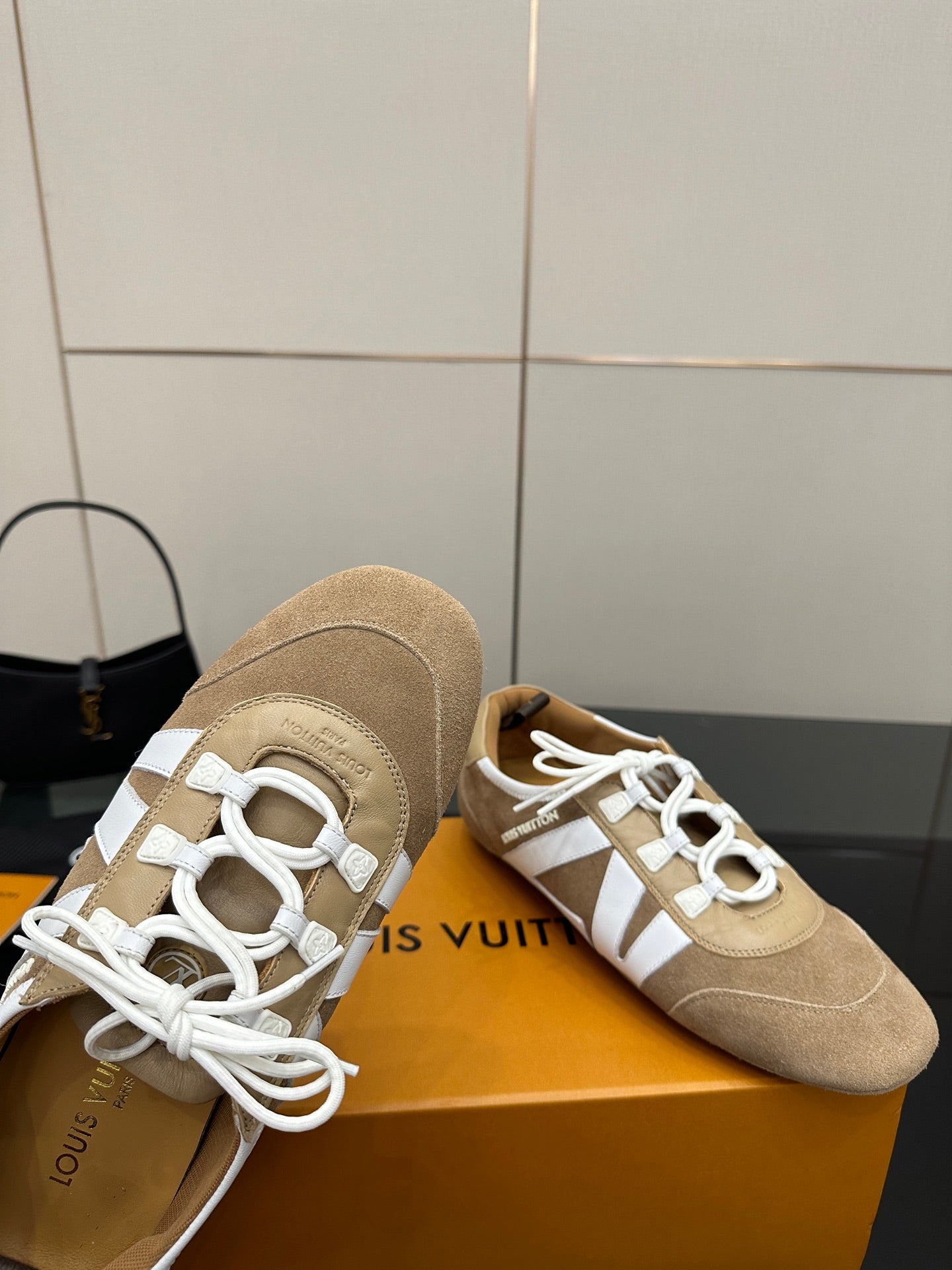 Louis Vuitton women’s beige sneakers close-up with white laces and textured toe area
