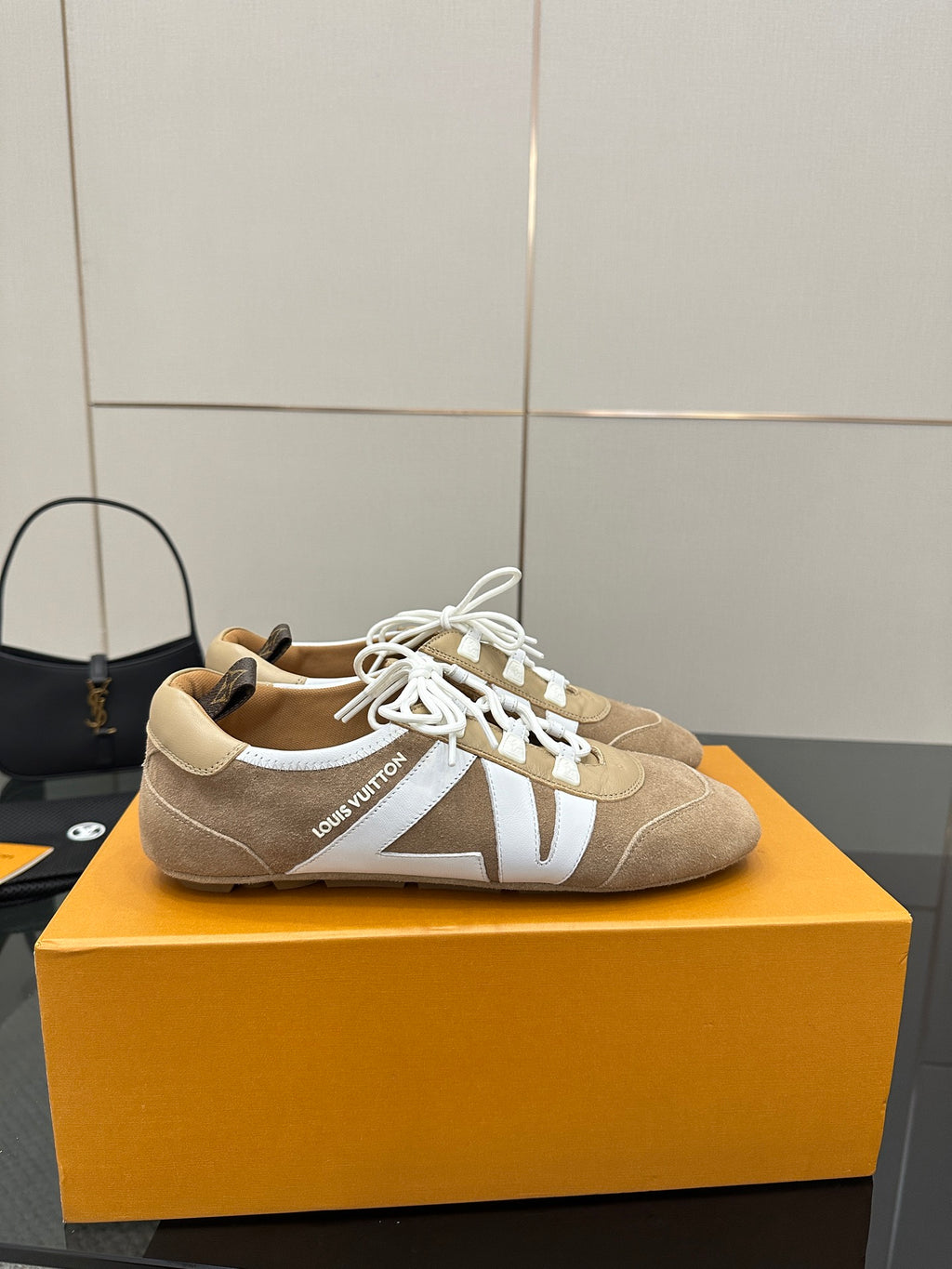 Louis Vuitton women’s beige sneakers with white laces, side straps, and low profile sole