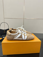 Louis Vuitton women’s beige sneakers with white laces, side straps, and low profile sole