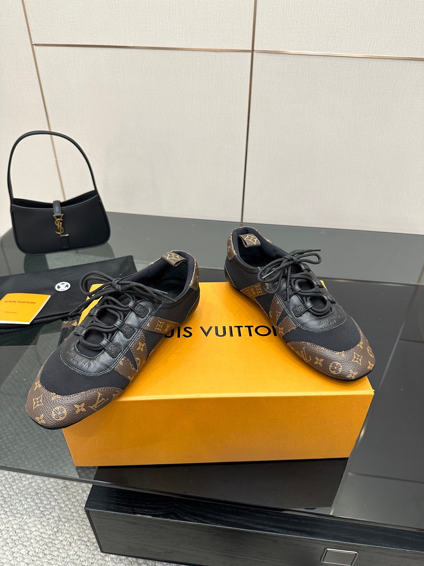 Louis Vuitton lace-up sneakers with black laces, monogram pattern and rubber sole