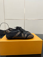 Louis Vuitton lace-up sneakers on side view, dark monogram pattern and black laces
