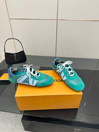 Teal low-top sneakers with white laces and light blue side stripe on yellow box
