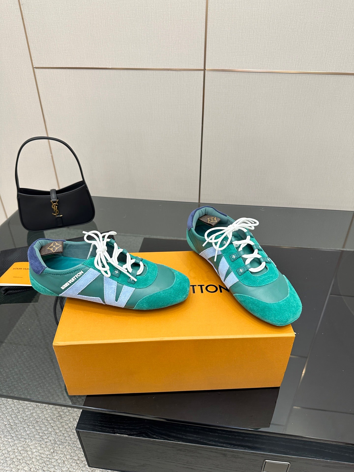 Teal low-top sneakers with white laces and light blue side stripe on yellow box
