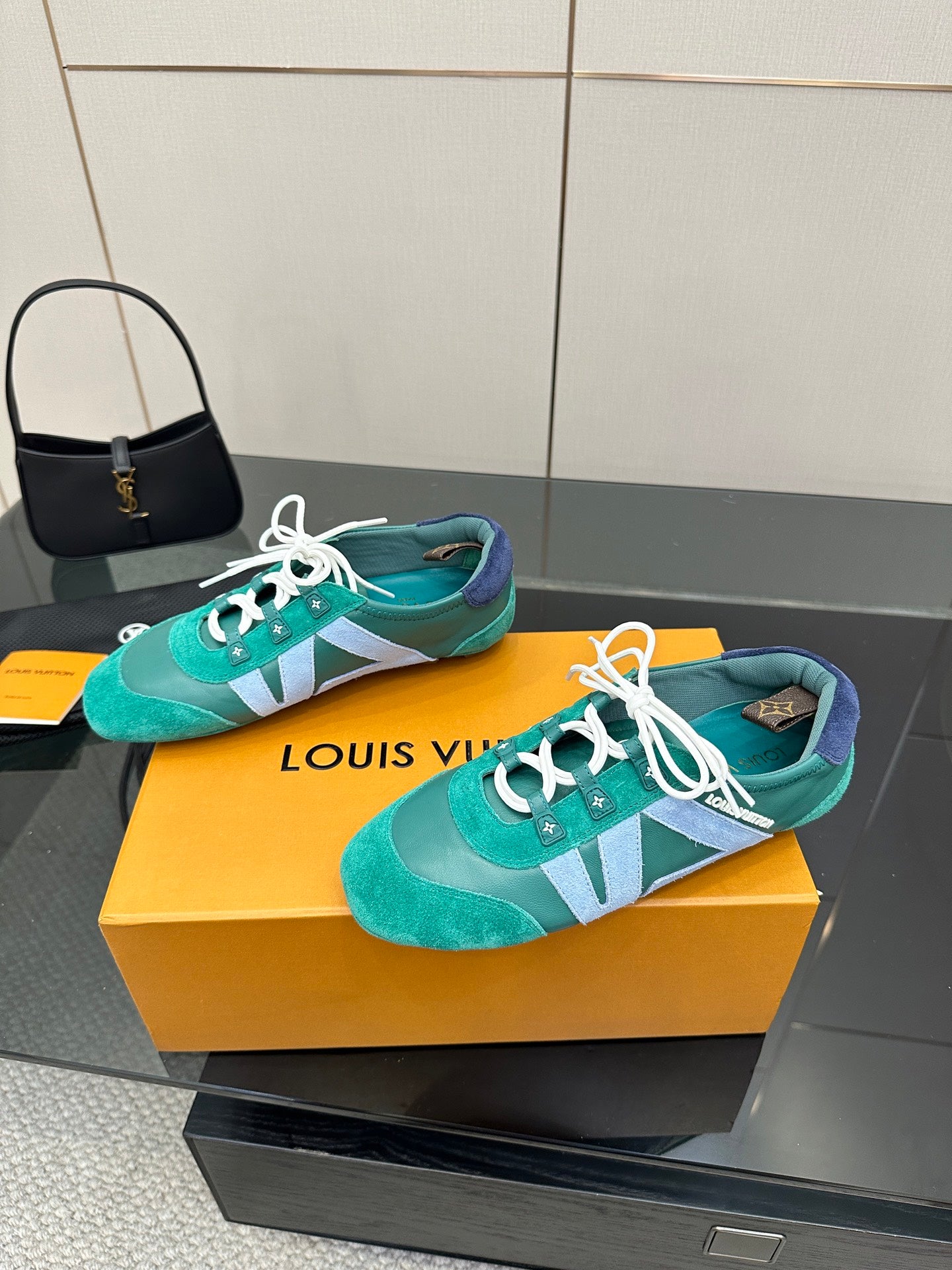 Pair of teal low-top sneakers with white laces and light blue side stripe detail