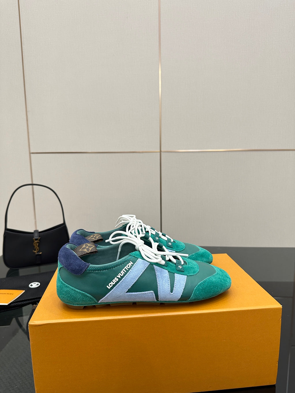 Teal low-top sneakers with white laces and light blue side stripe detail on box
