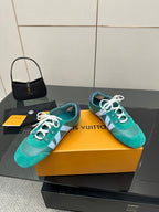 Teal low-top sneakers on box, white laces and light blue side stripe detail