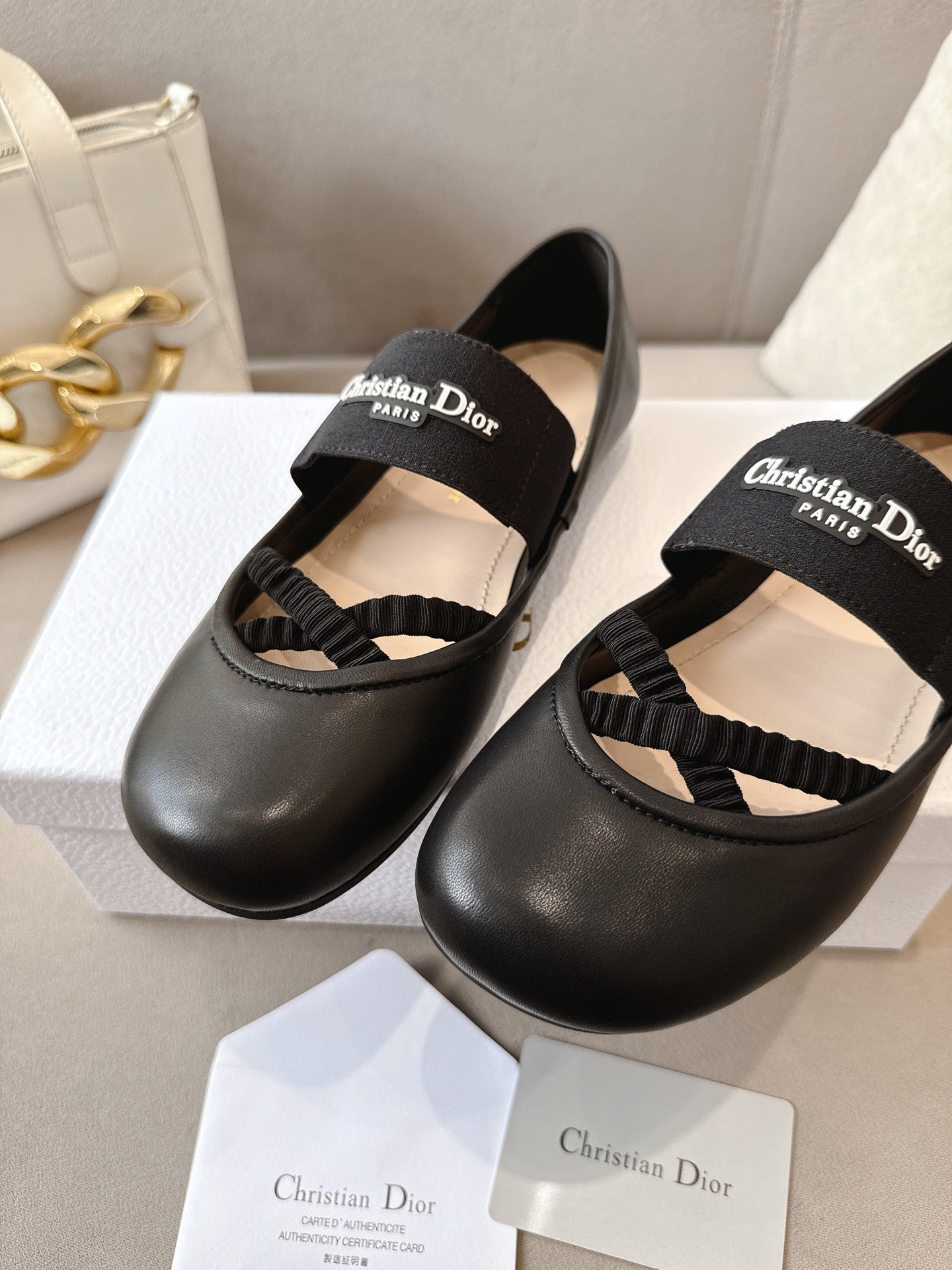 Black women's ballet flats with crisscross strap and logo on top strap.