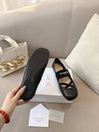 Black women's ballet flats with textured rubber sole and crisscross strap.
